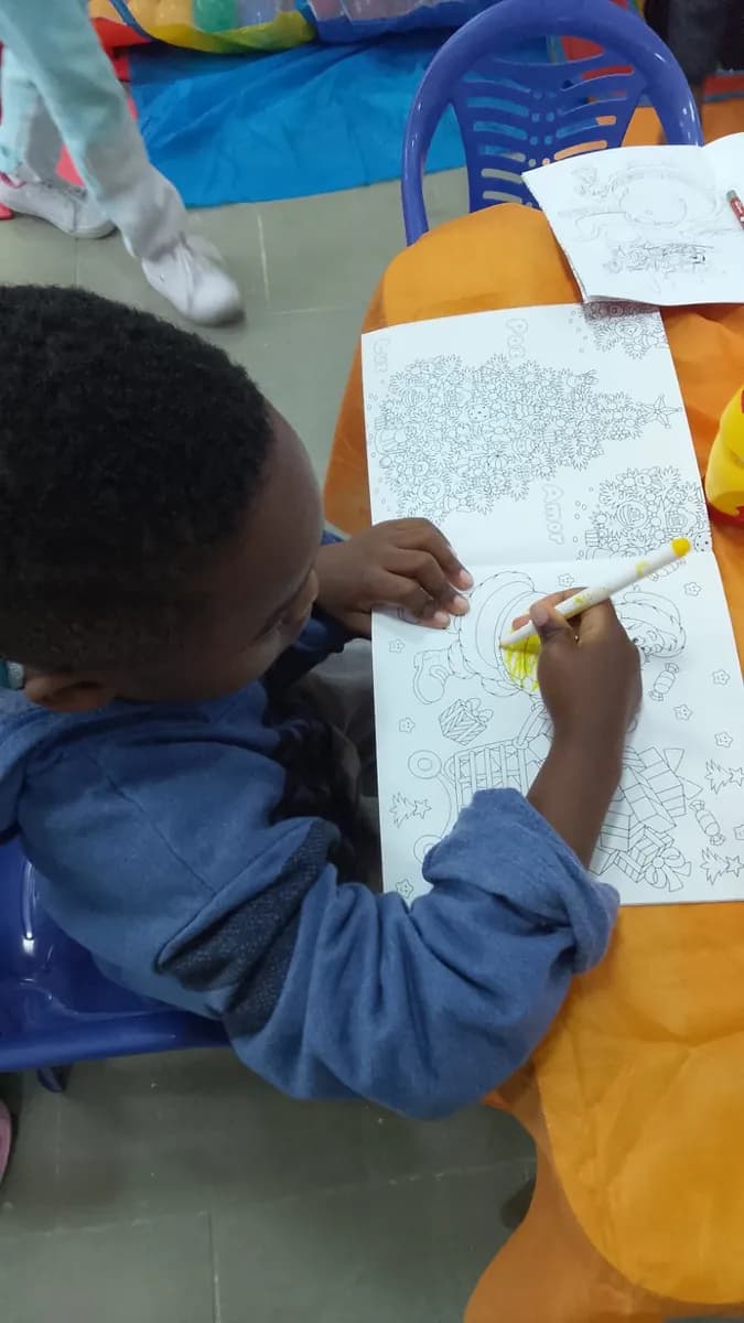 Menino colorindo um desenho de Natal durante a atividade