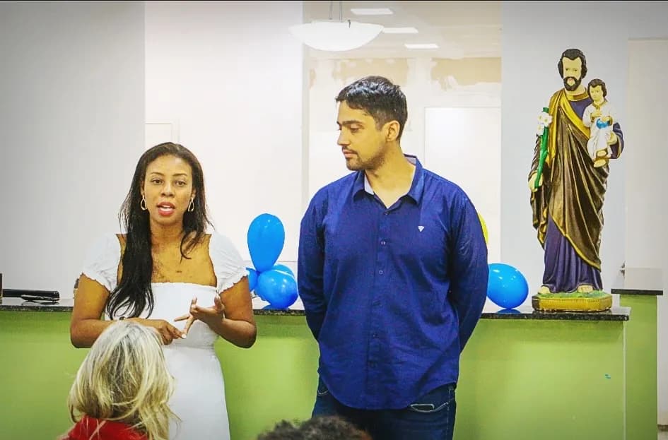 Liziene e Felipe, fundadores da AAPI-SJ, falando às famílias ao lado da imagem de São José