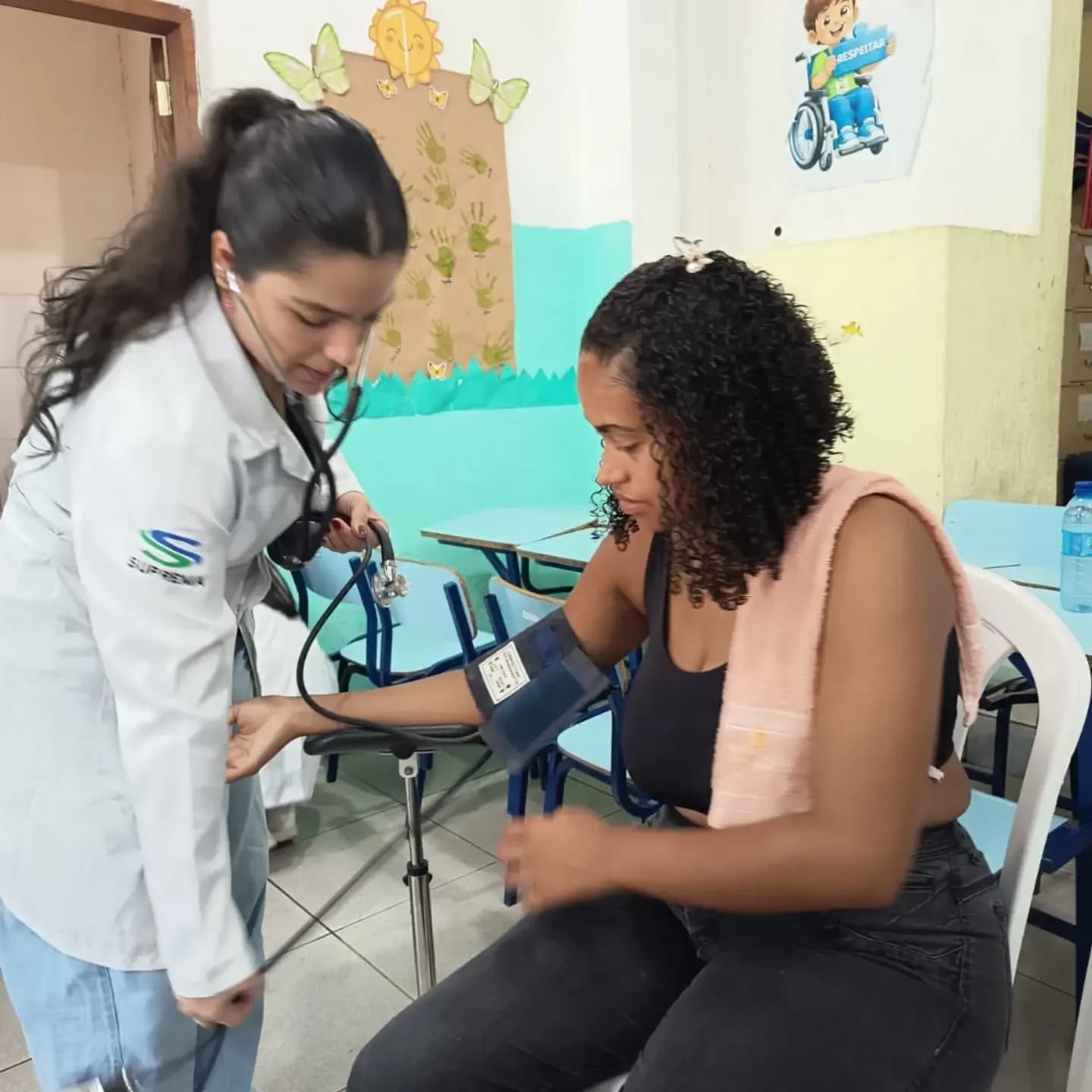 Estudante de Medicina medindo a pressão de uma mãe