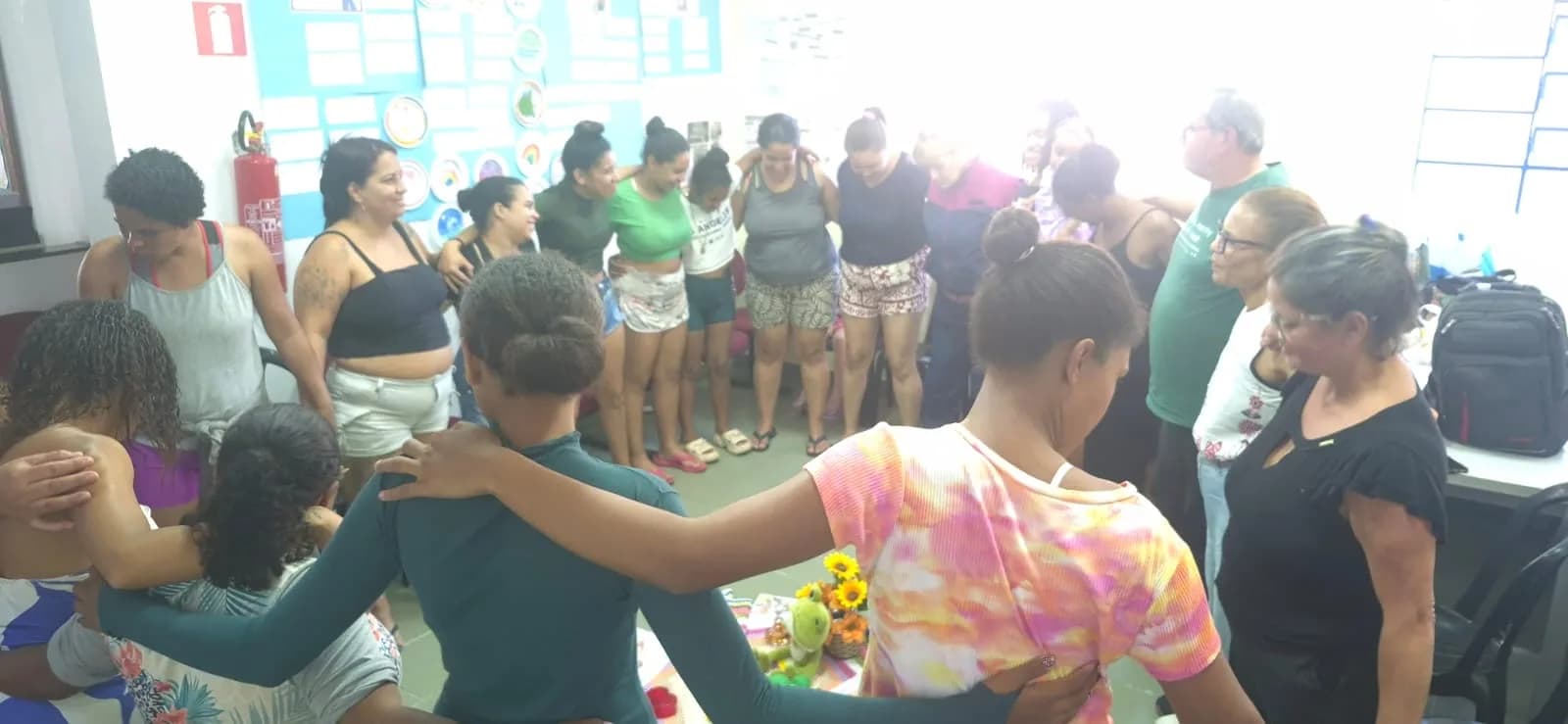 Mães reunidas em roda, de mãos dadas, na Terapia Comunitária Integrativa