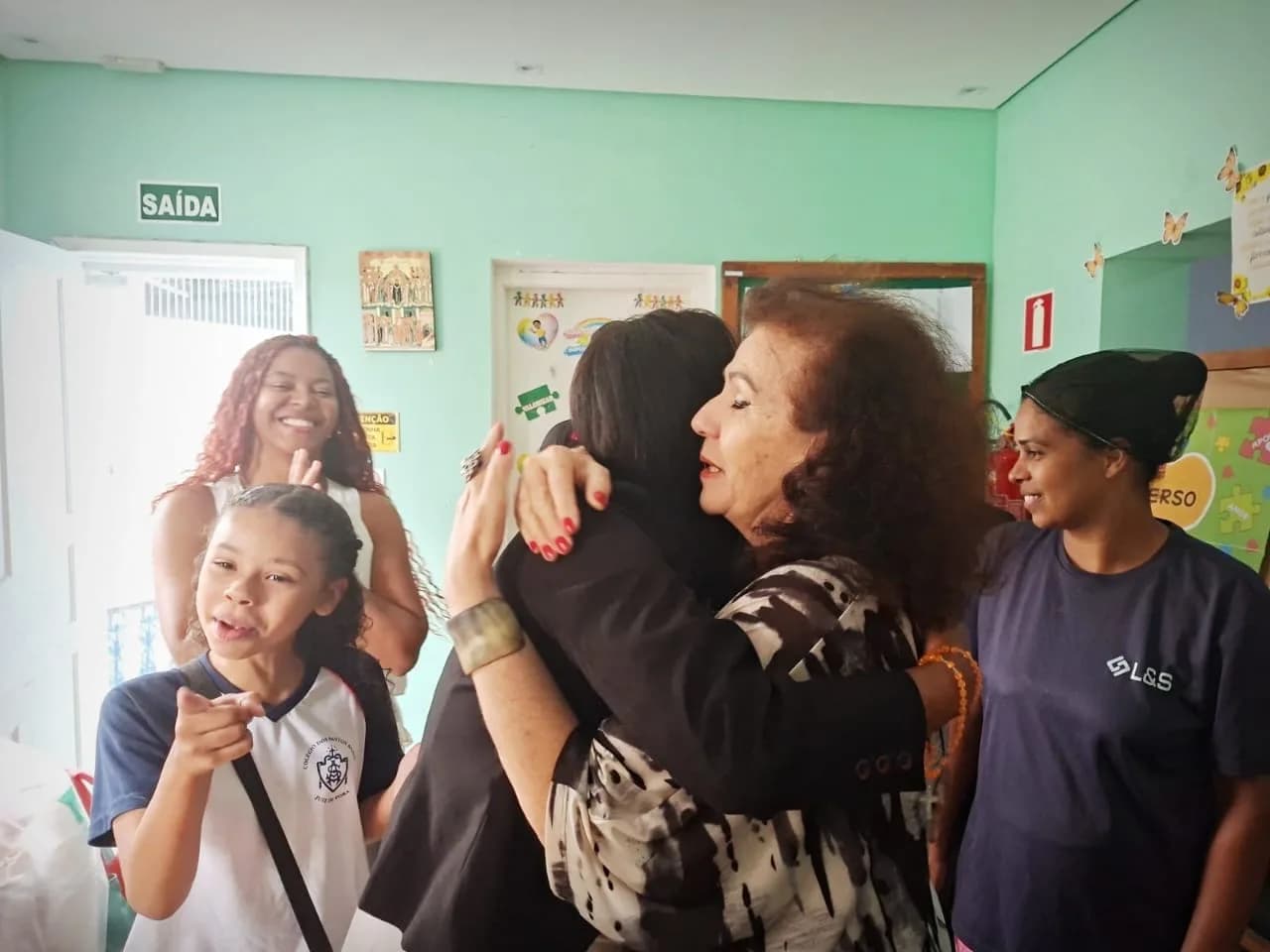 Liziene Rodrigues recebendo um abraço da equipe no aniversário