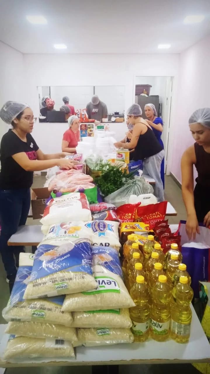 Voluntários organizando arroz, óleo e outros alimentos doados