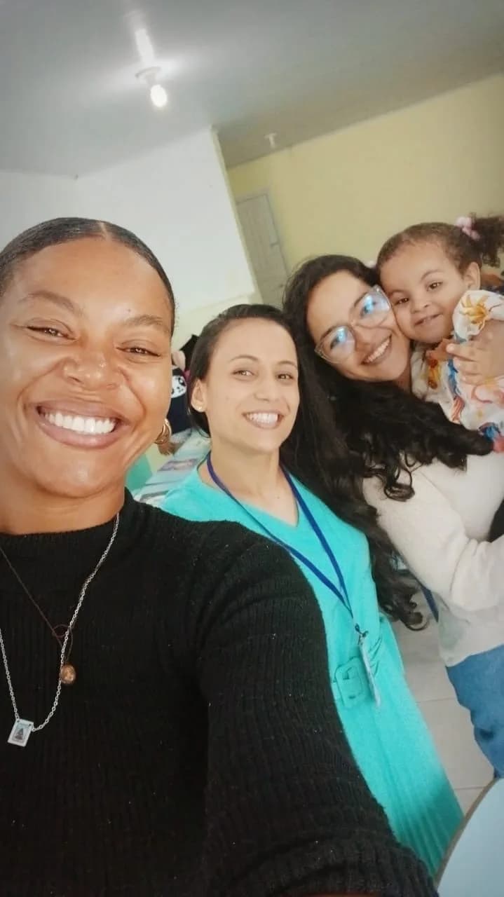 Equipe da AAPI-SJ com uma criança no colo