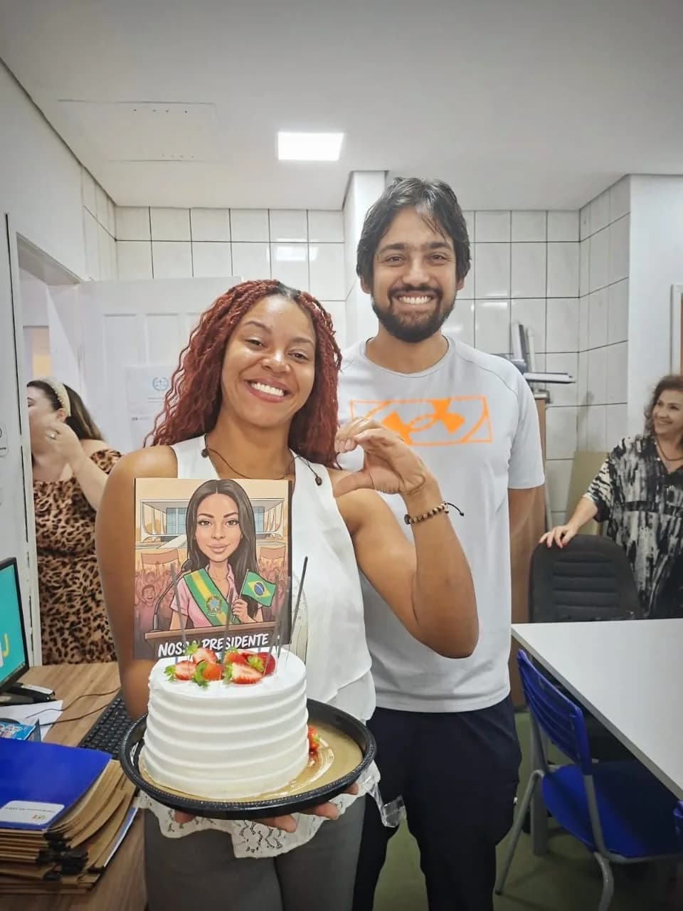 Liziene Rodrigues sorrindo com o bolo de aniversário