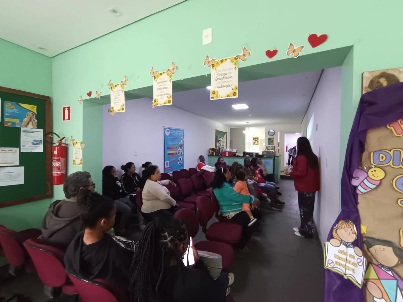 Famílias reunidas no corredor da sede para o encontro de sábado do SCFV