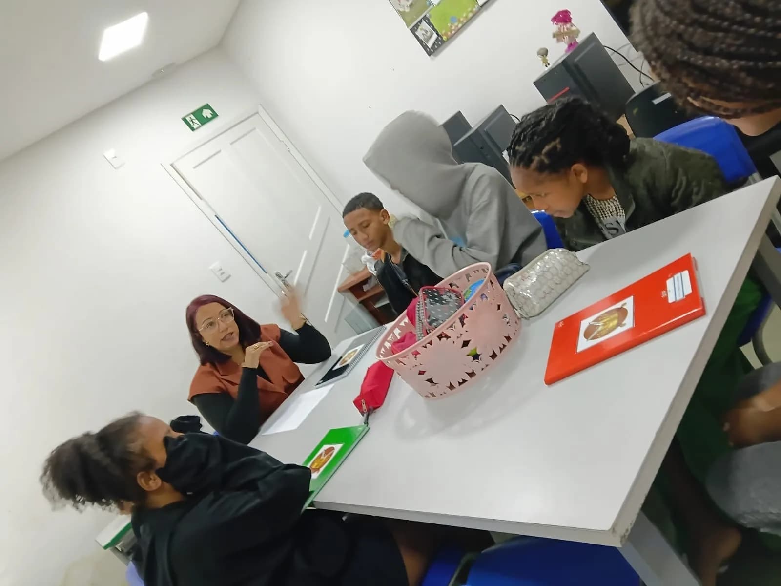 Educadora conversando com os adolescentes sobre as profissões