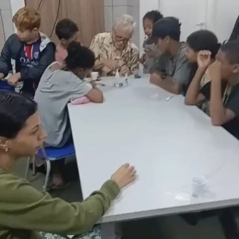 Crianças e adolescentes em volta da mesa de robótica