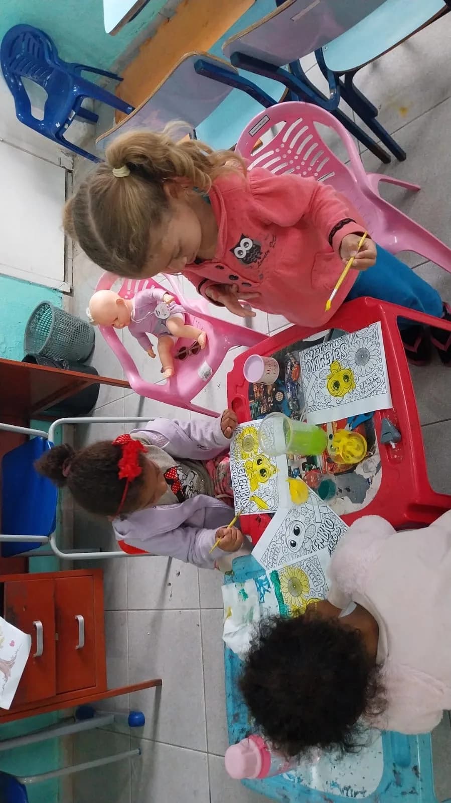 Crianças pintando a atividade do Setembro Amarelo com girassóis