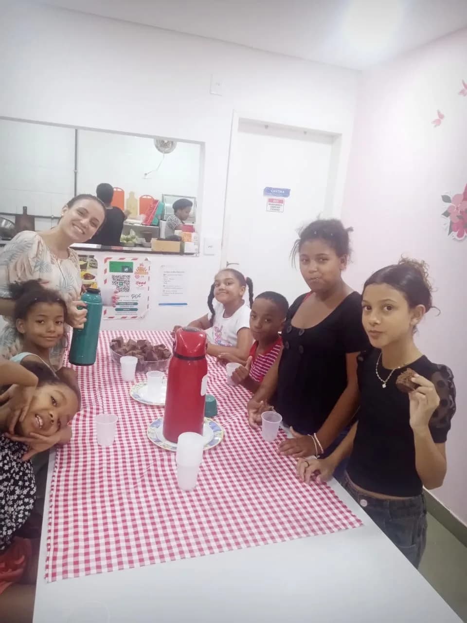 Crianças e adolescentes lanchando com biscoitos e suco