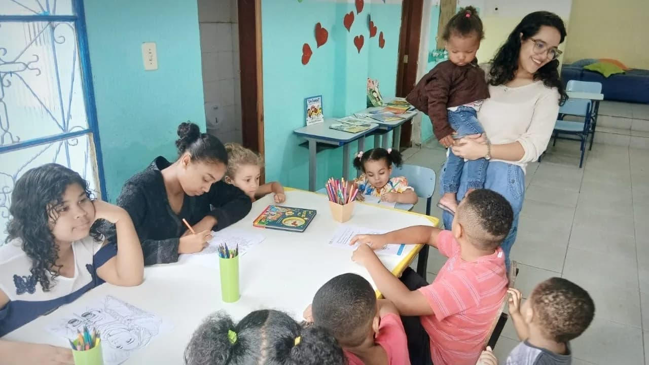 Voluntária ajudando as crianças a colorir desenhos