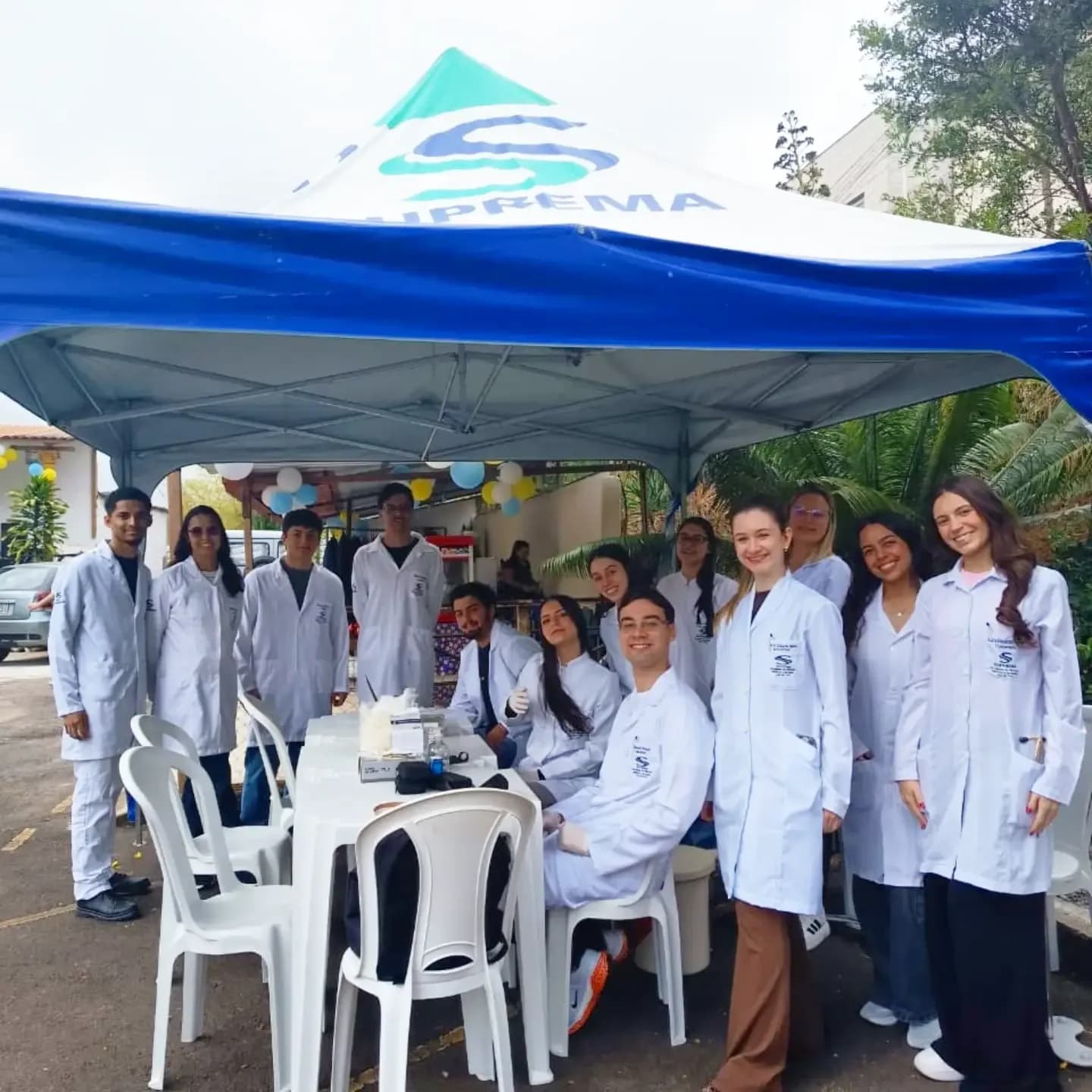 Estudantes de saúde de jaleco na tenda de atendimentos