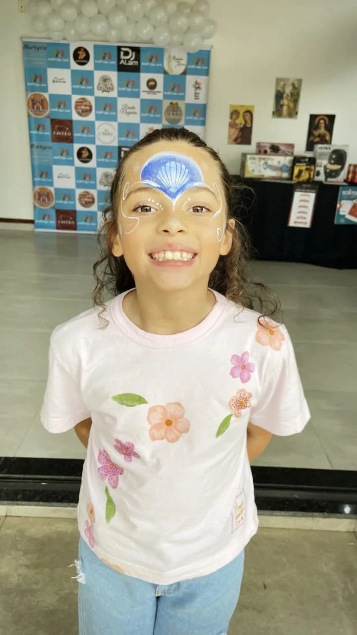 Menina sorrindo com pintura de rosto na festa