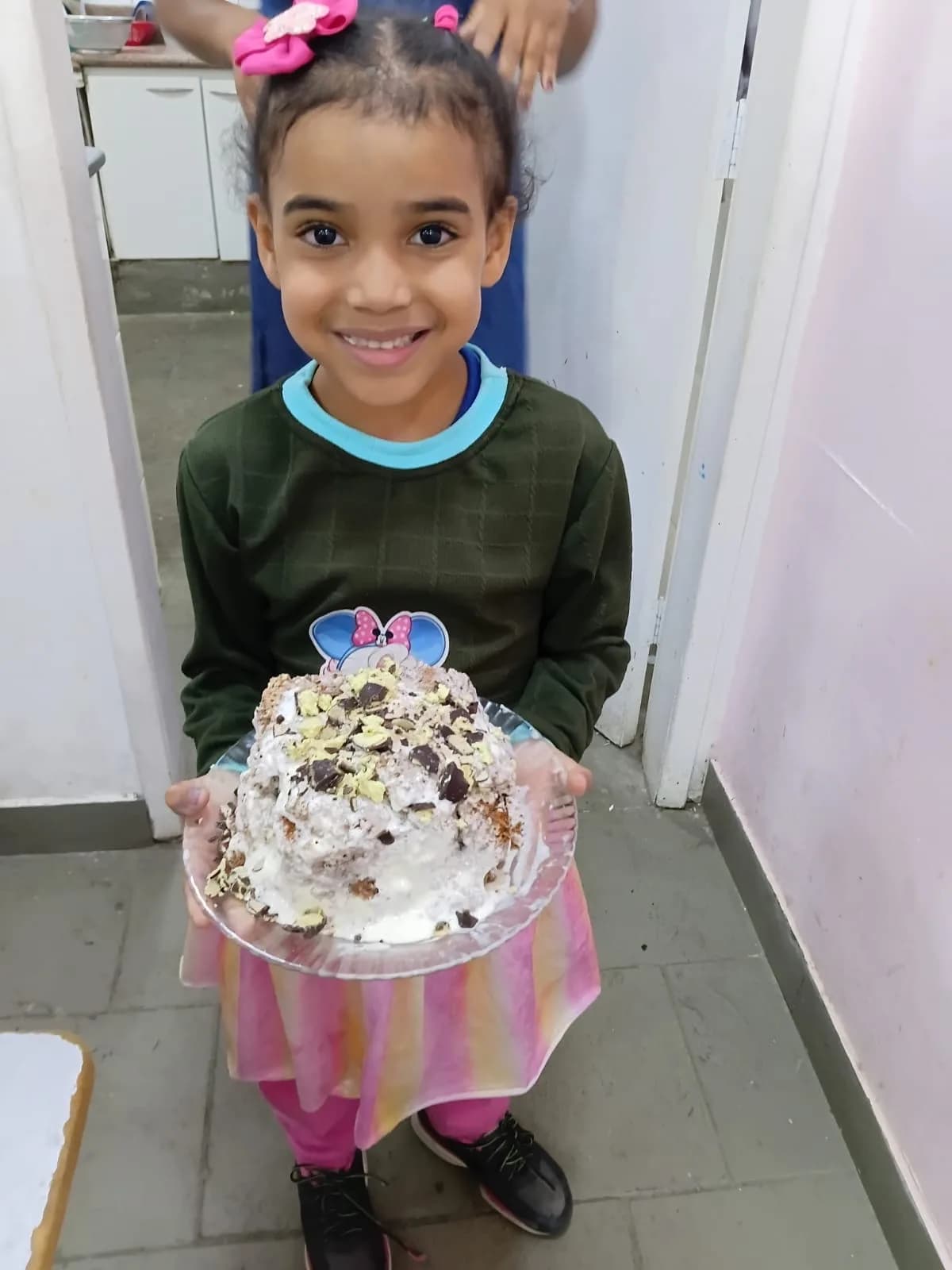 Rayla sorrindo com o bolinho de aniversário nas mãos