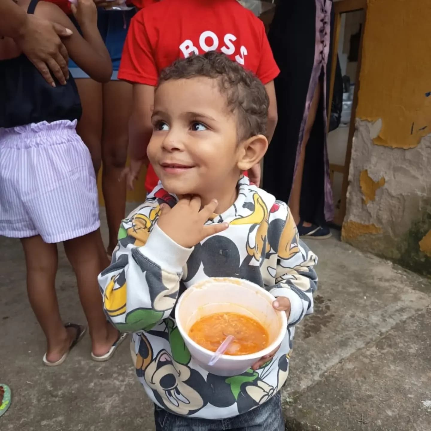 Menino com um copo de sopa na festa