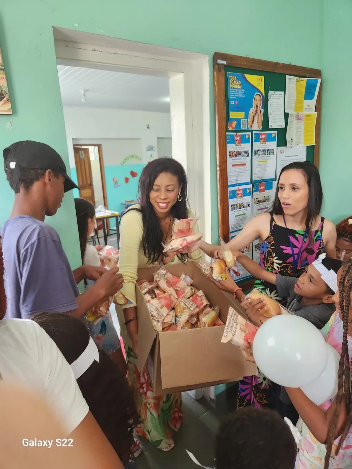 Equipe distribuindo os pães da Páscoa às crianças