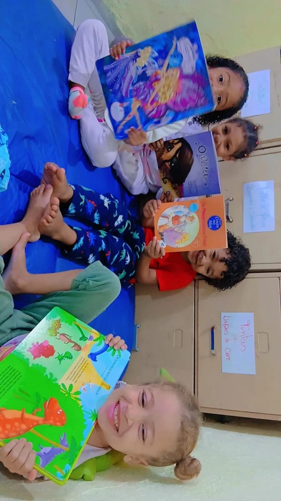 Crianças mostrando os livros escolhidos no momento de leitura