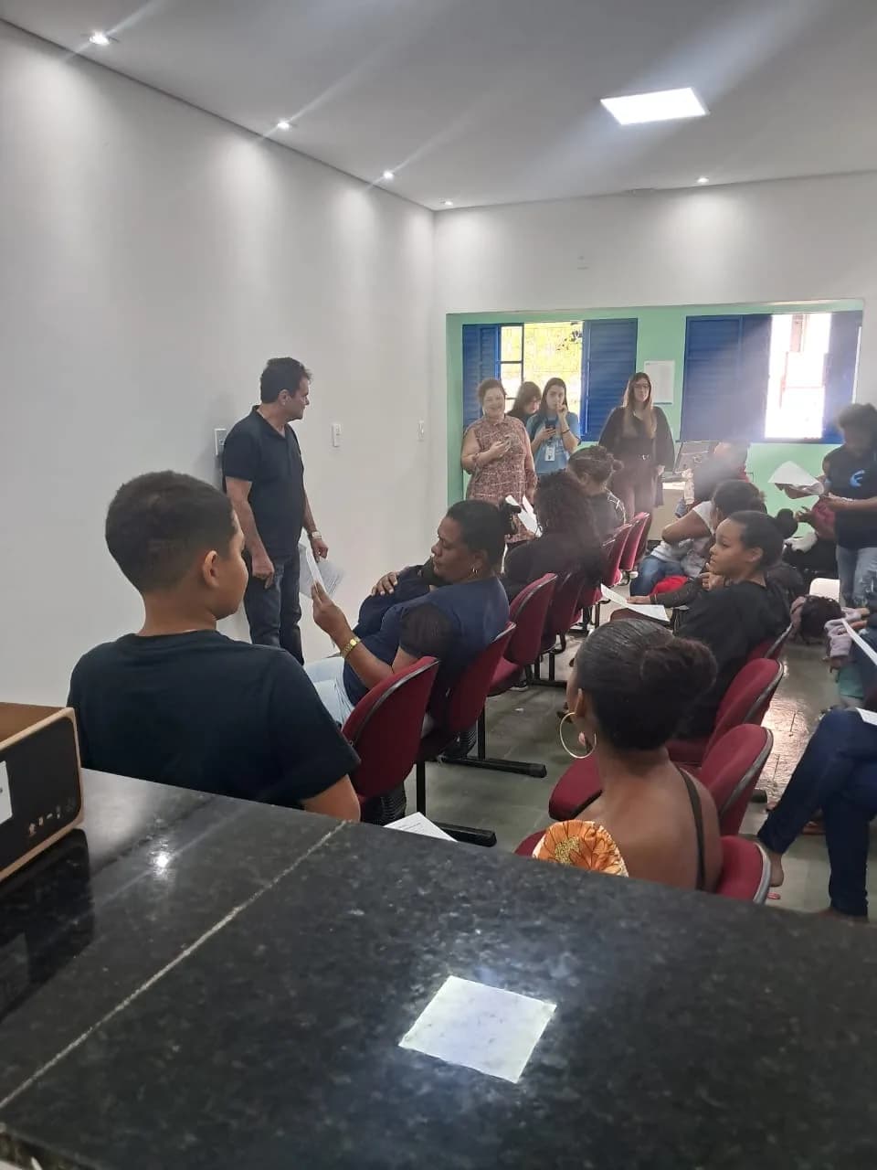 Famílias acompanhando a palestra com os materiais em mãos