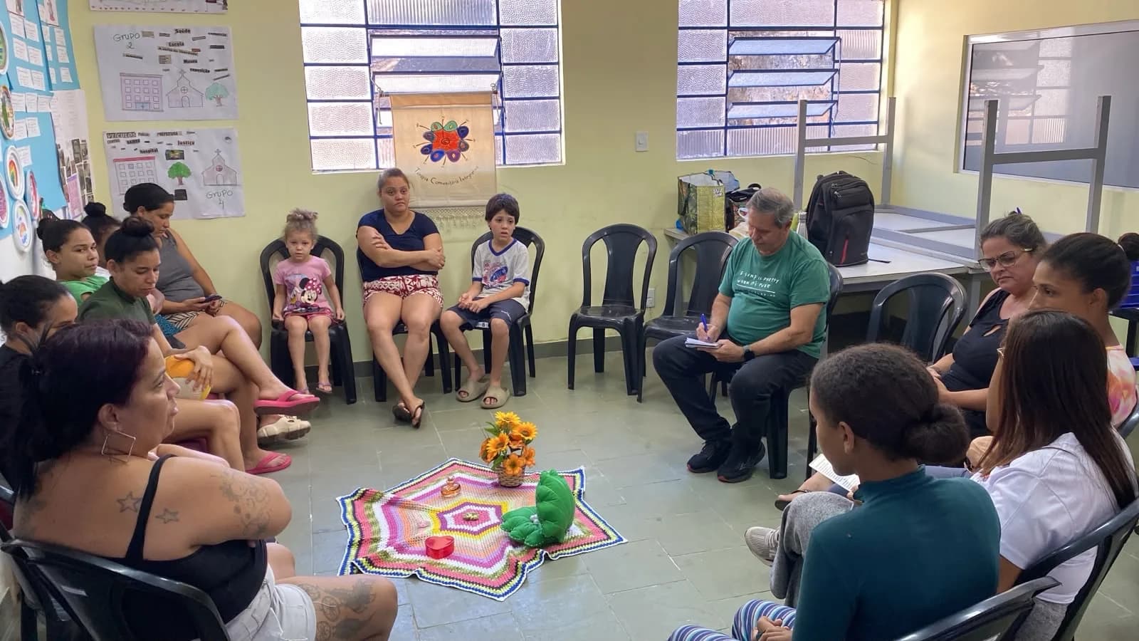 Mães e crianças sentadas em círculo durante a Terapia Comunitária Integrativa