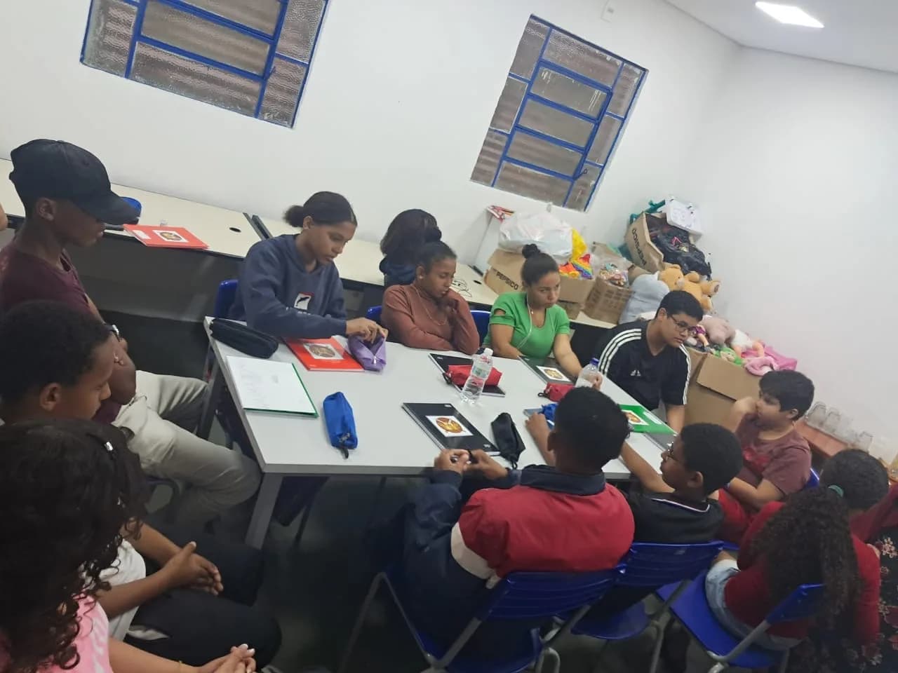 Adolescentes reunidos à mesa durante a palestra