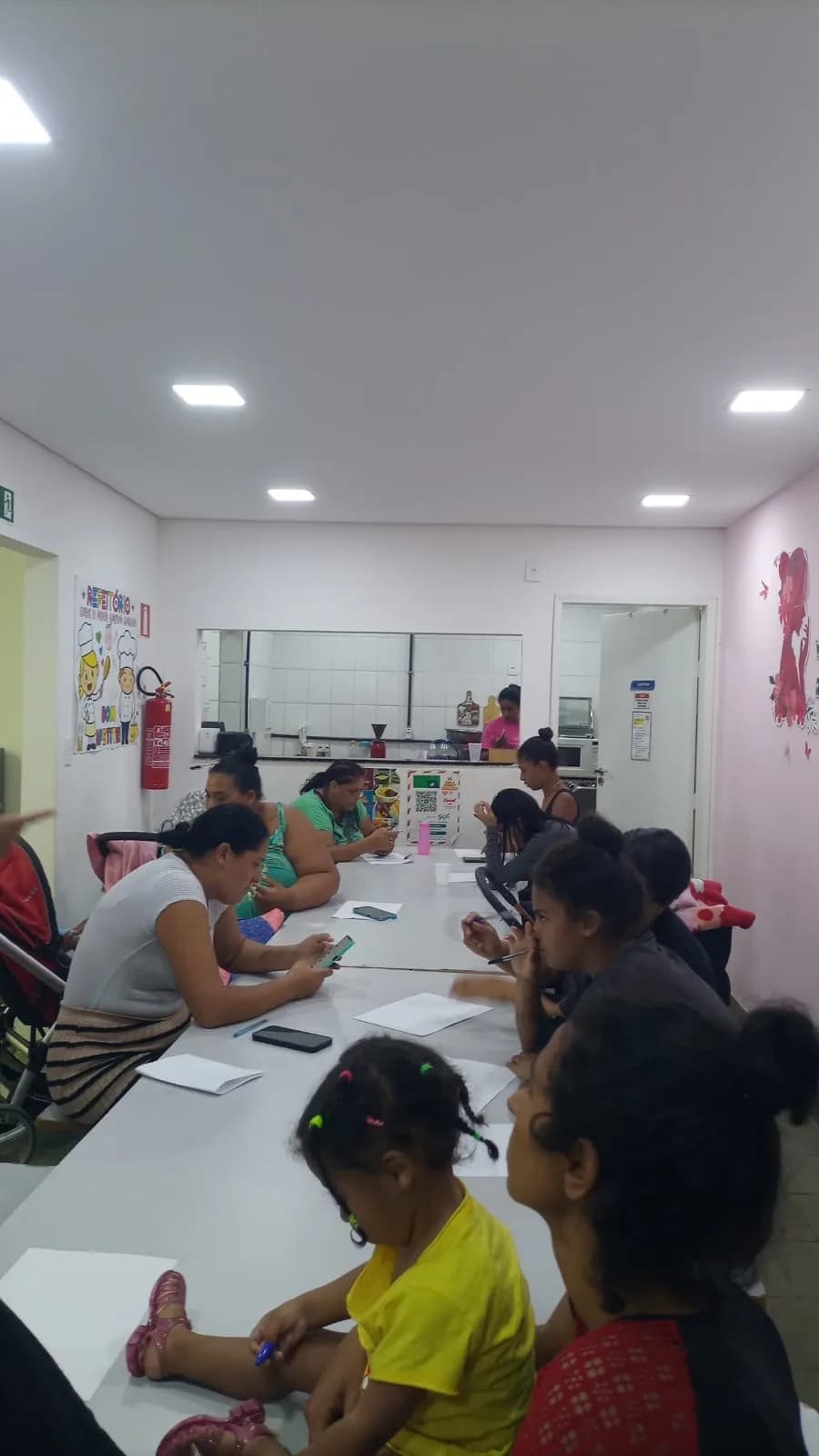 Mães reunidas à mesa durante o encontro do SCFV