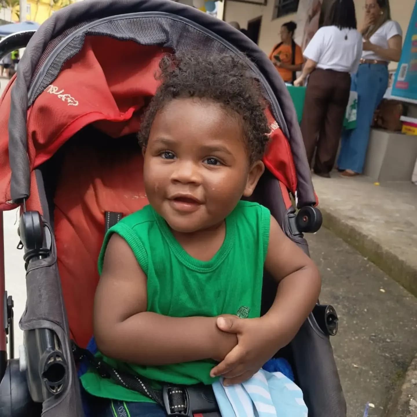 Bebê sorridente no carrinho durante a festa