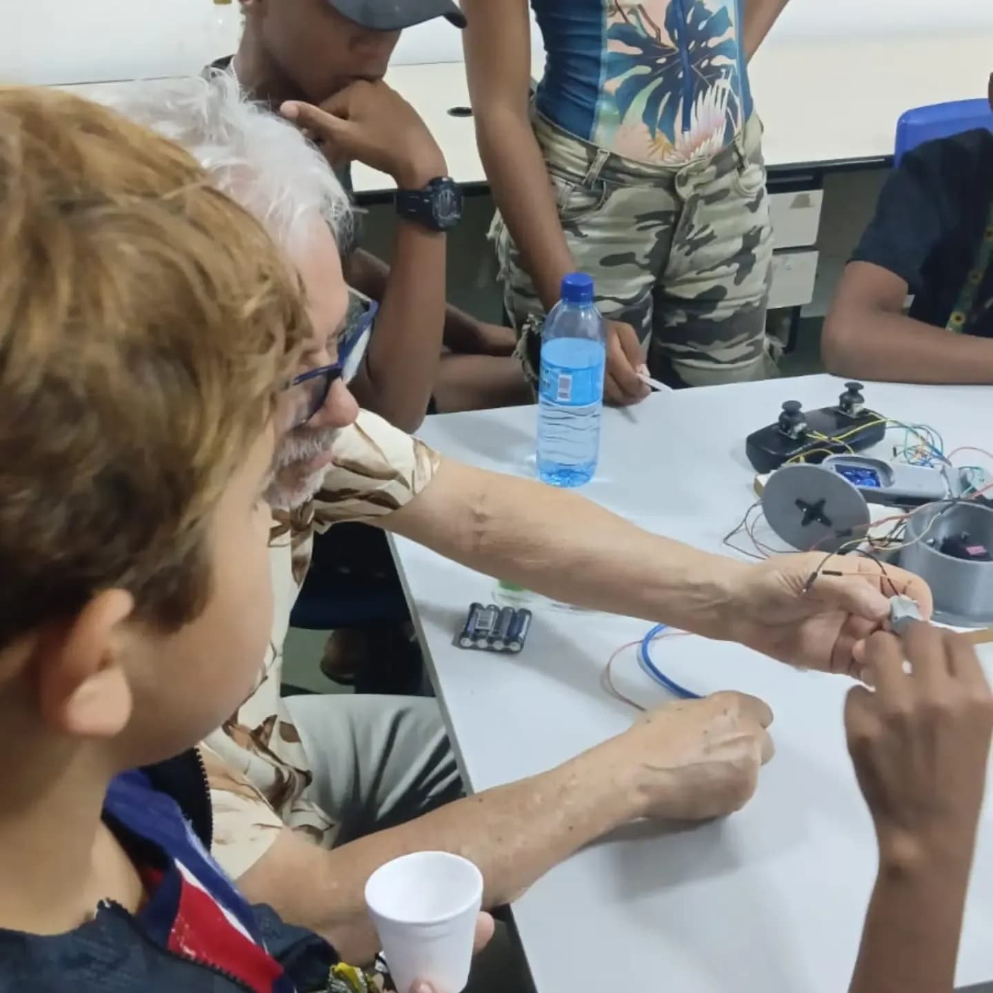 Crianças observando de perto os componentes do robô