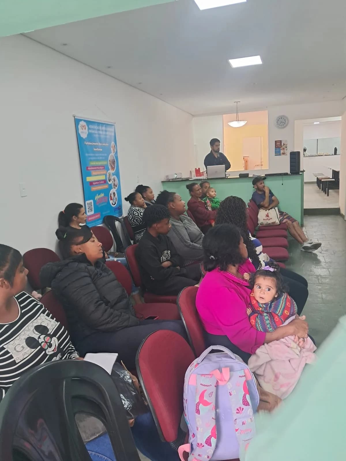 Mães, pais e crianças acompanhando a palestra da Dra. Angelyca Brandi