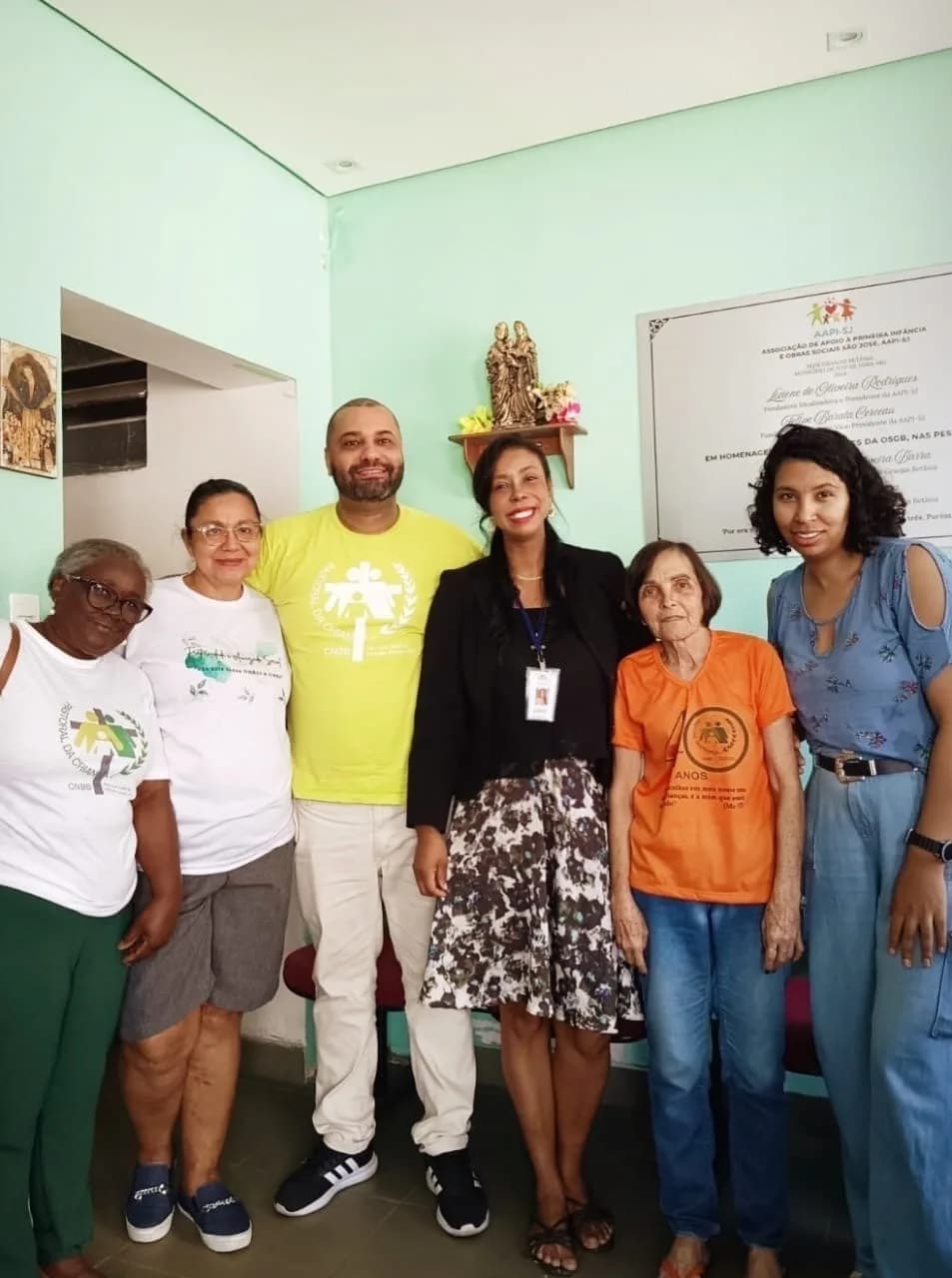 Voluntário ajustando os componentes do braço robótico no estande de Robótica