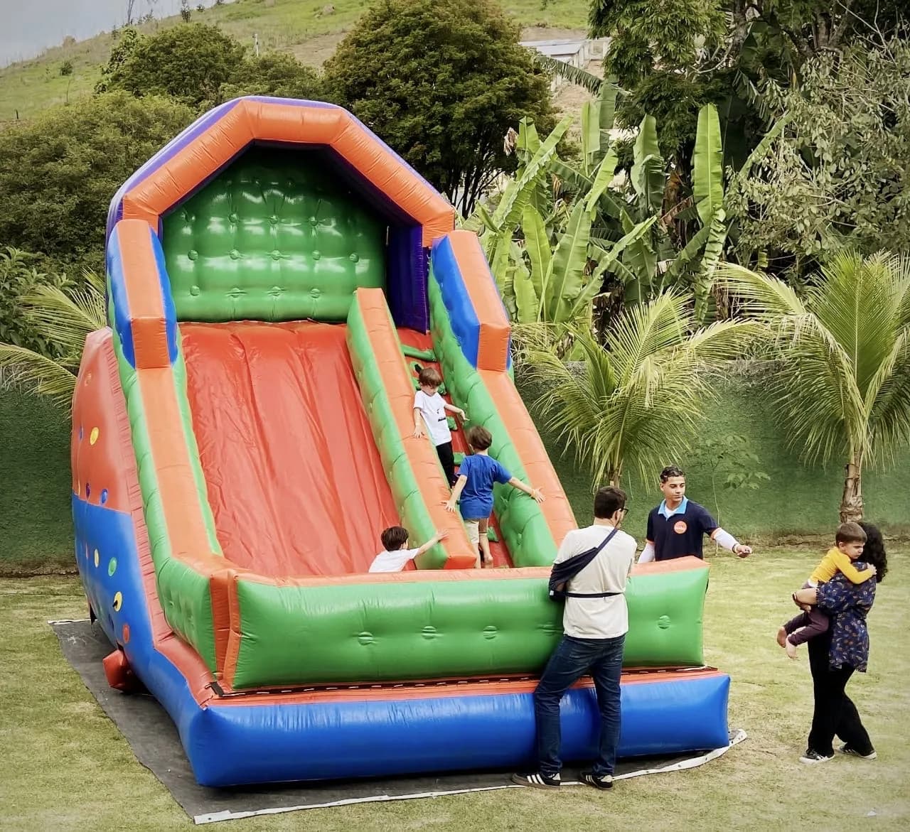 Crianças brincando no escorregador inflável
