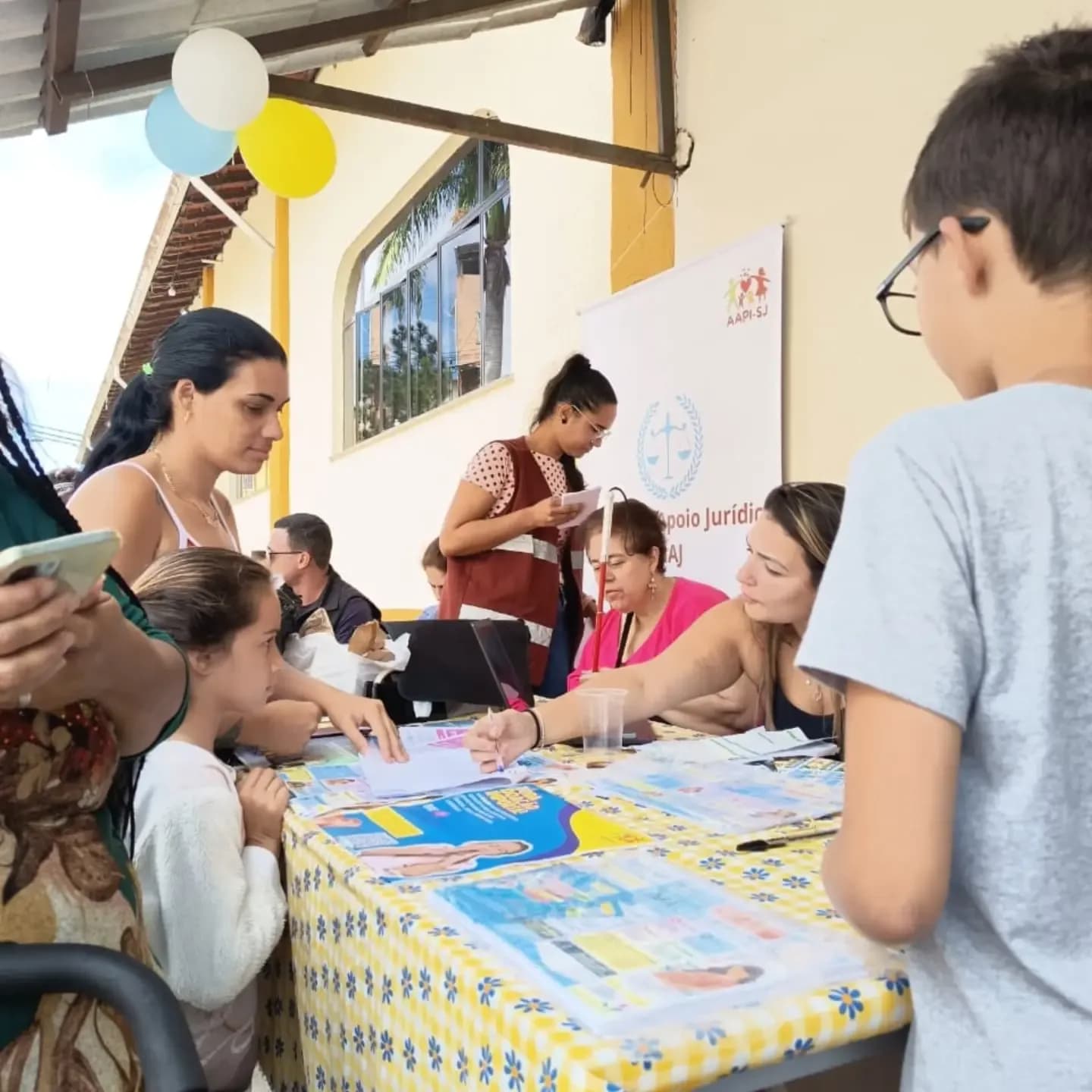 Crianças e mães na mesa de atividades
