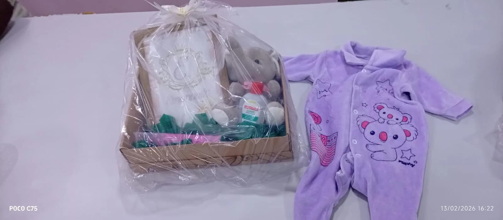 Cesta de presentes e macacão de bebê recebidos no Chá de Bênçãos