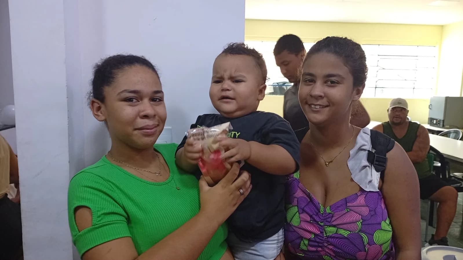 Mães e bebê recebendo o pão da Páscoa