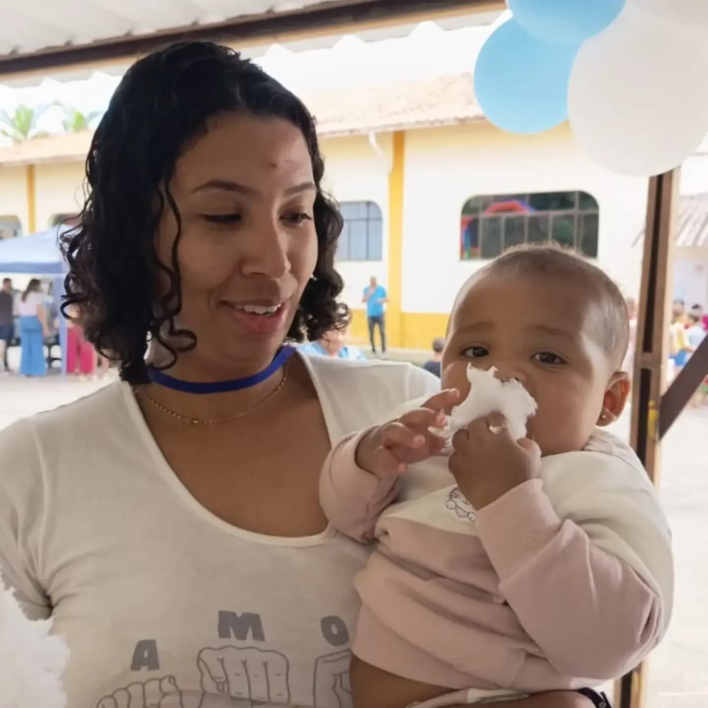 Mãe com seu bebê no colo durante a festa