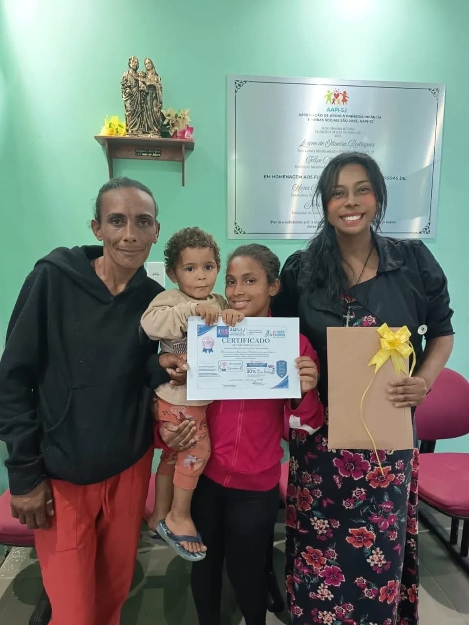 Família com o certificado de conclusão de ciclo do programa Cores e Ritmos