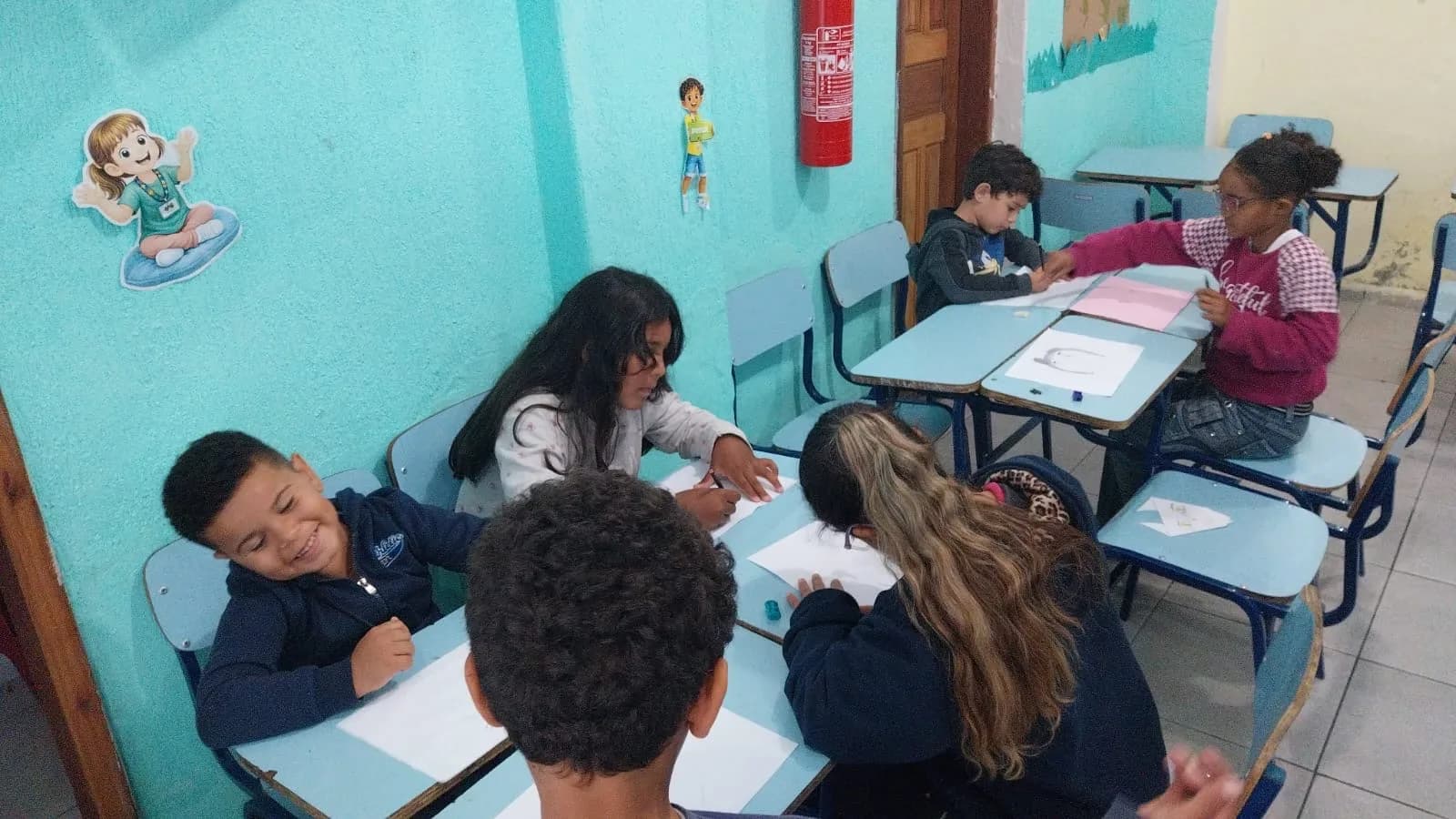 Crianças em duplas fazendo atividade de desenho nas carteiras