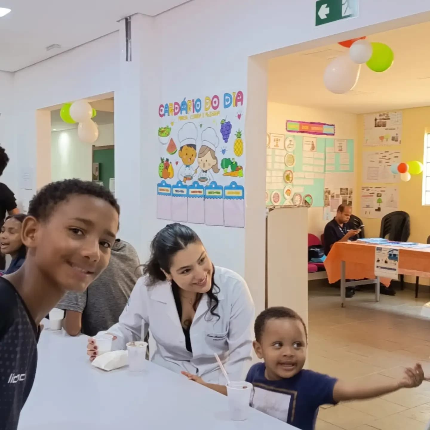 Crianças sorrindo com uma estudante de Odontologia