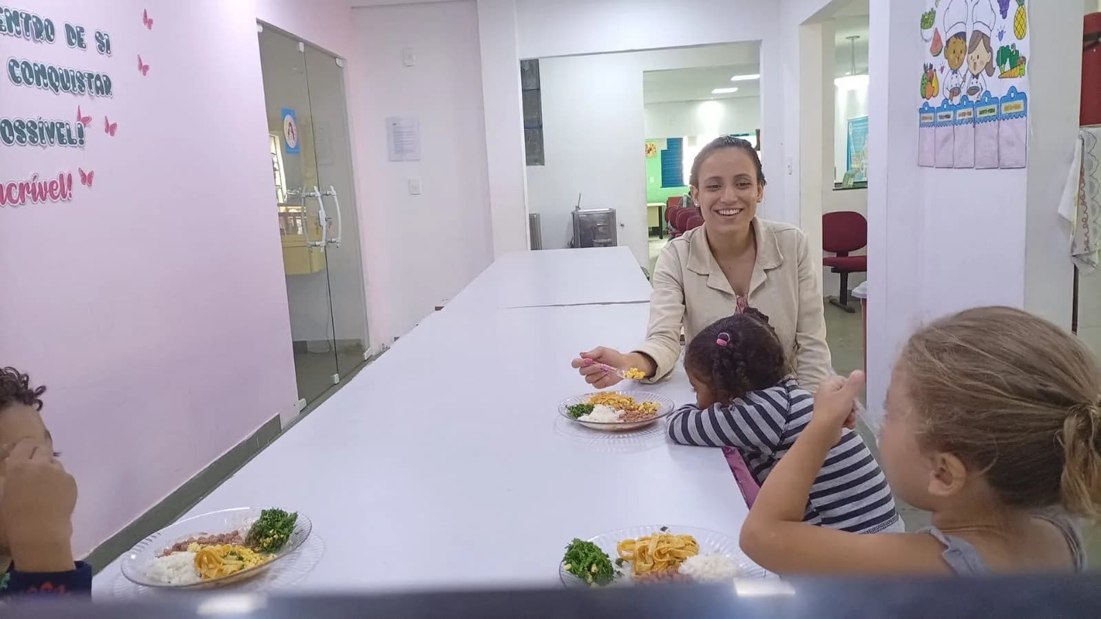 Voluntária almoçando com as crianças no refeitório