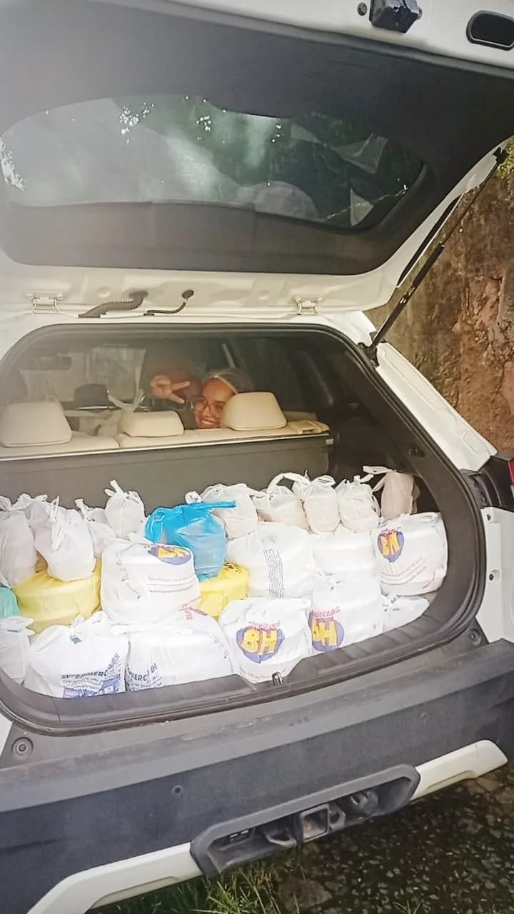 Porta-malas cheio de sacolas de alimentos doados