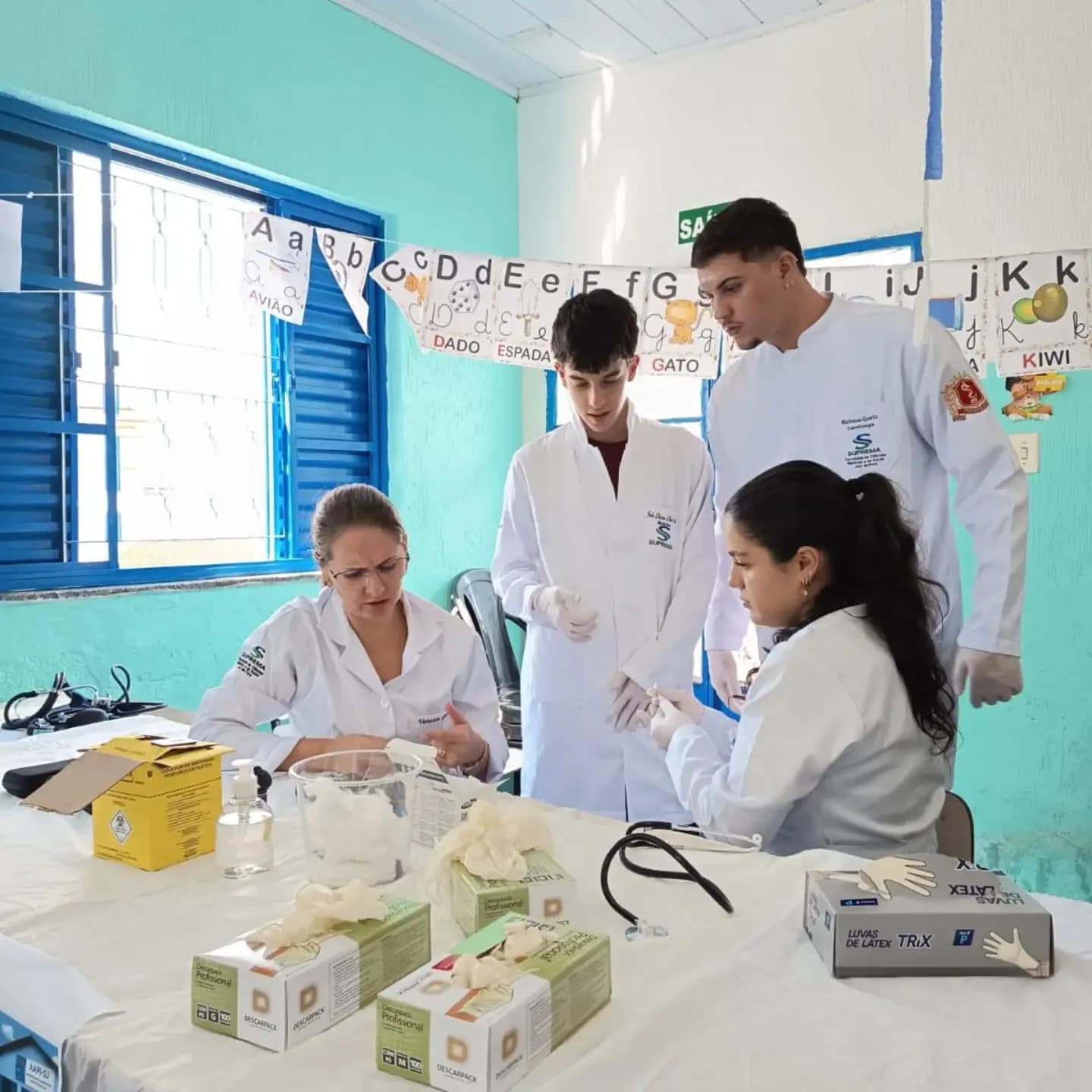 Estudantes de Medicina com uma criança na mesa