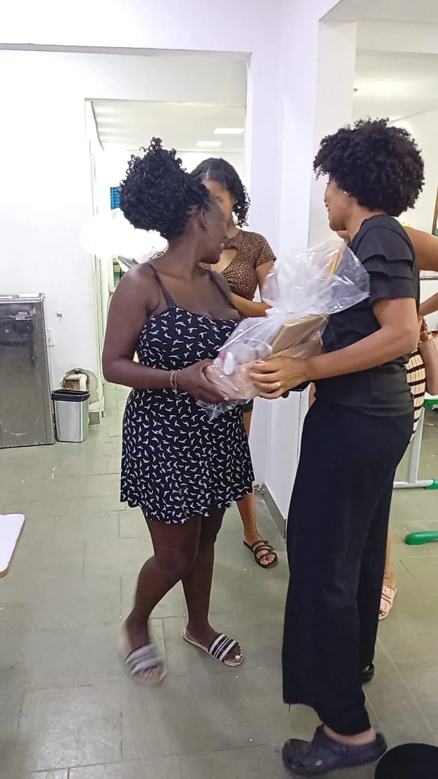 Equipe entregando a cesta de presentes a uma gestante