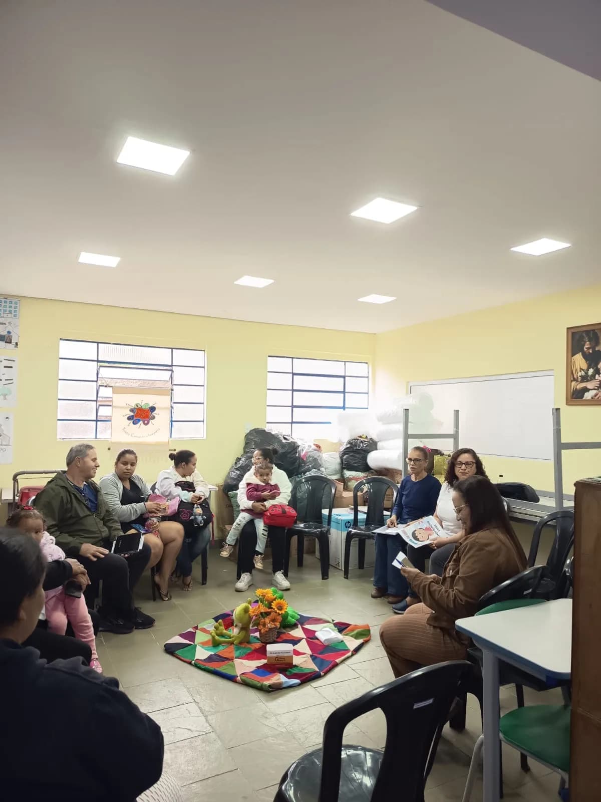 Famílias sentadas em roda com os bebês durante a Terapia Comunitária Integrativa