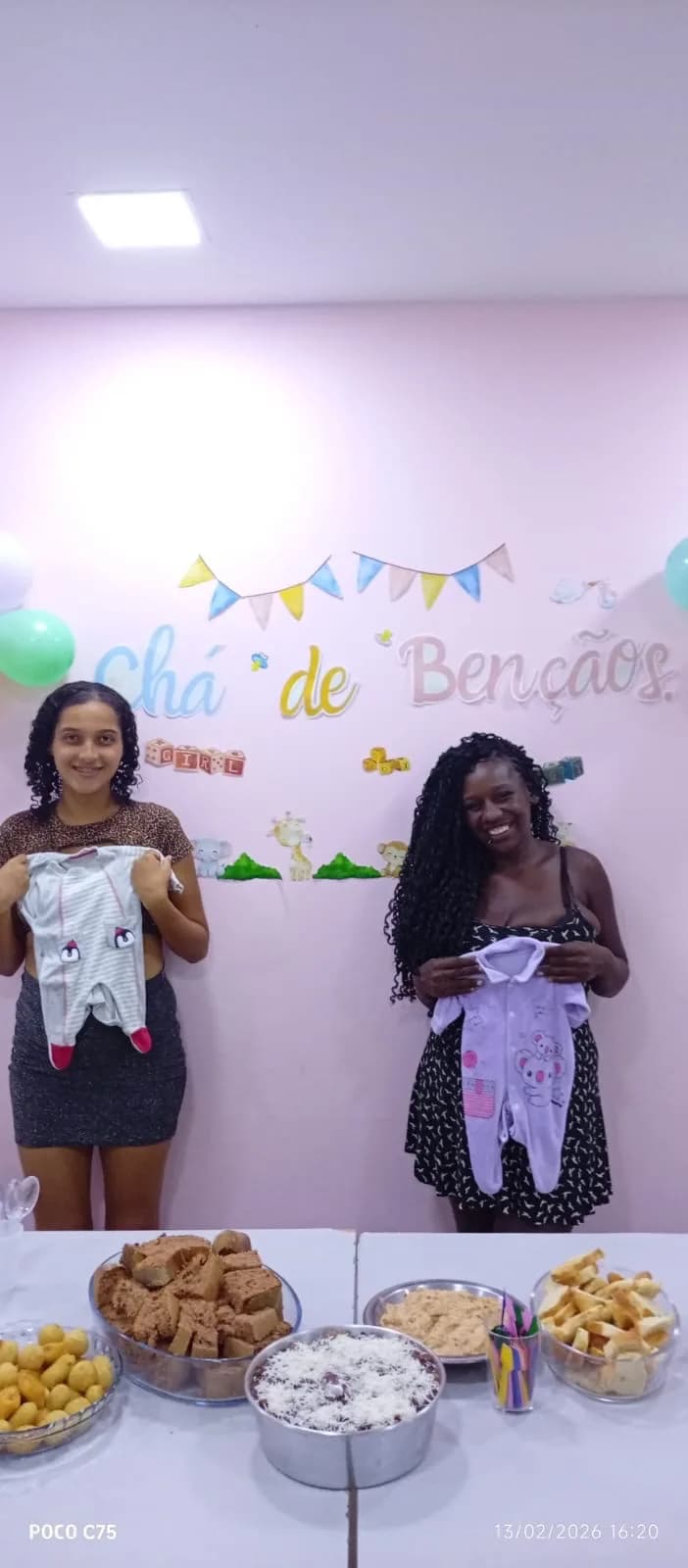 Gestantes com as roupinhas de bebê, diante da mesa de doces