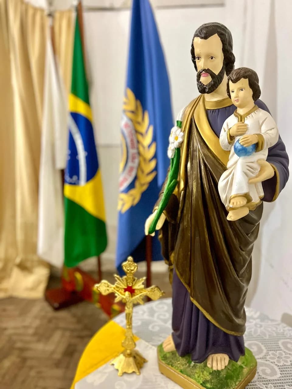 Imagem de São José com o Menino Jesus ao lado das bandeiras, no evento da associação