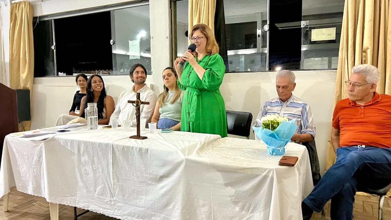 Presidente falando ao microfone na mesa de abertura